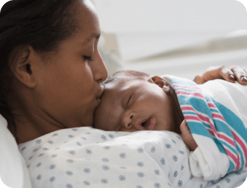 Mother kissing new born on forehead