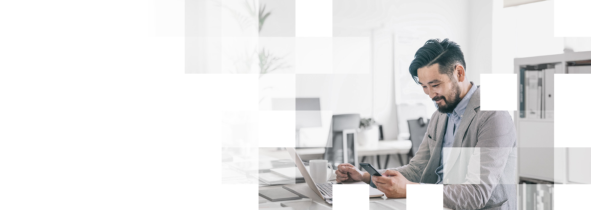 man at desk with laptop and phone