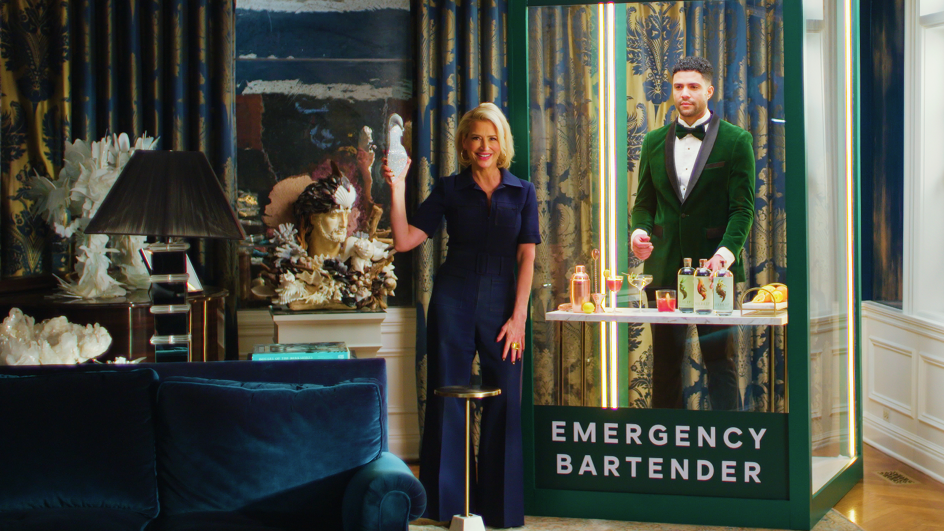 Dorinda with an emergency bartender inside a glass case.