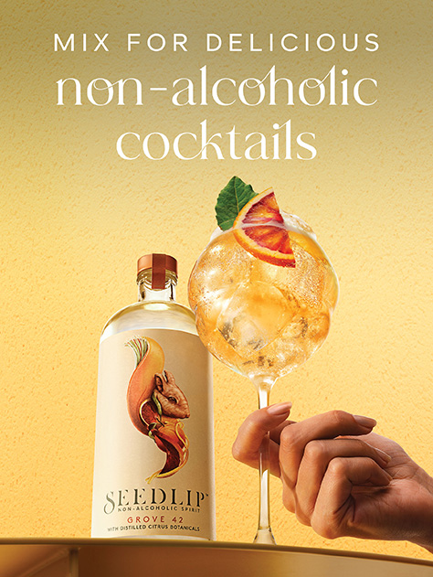 Seedlip Grove 42 non-alcoholic spirit bottle and cocktail with citrus garnish against a yellow background