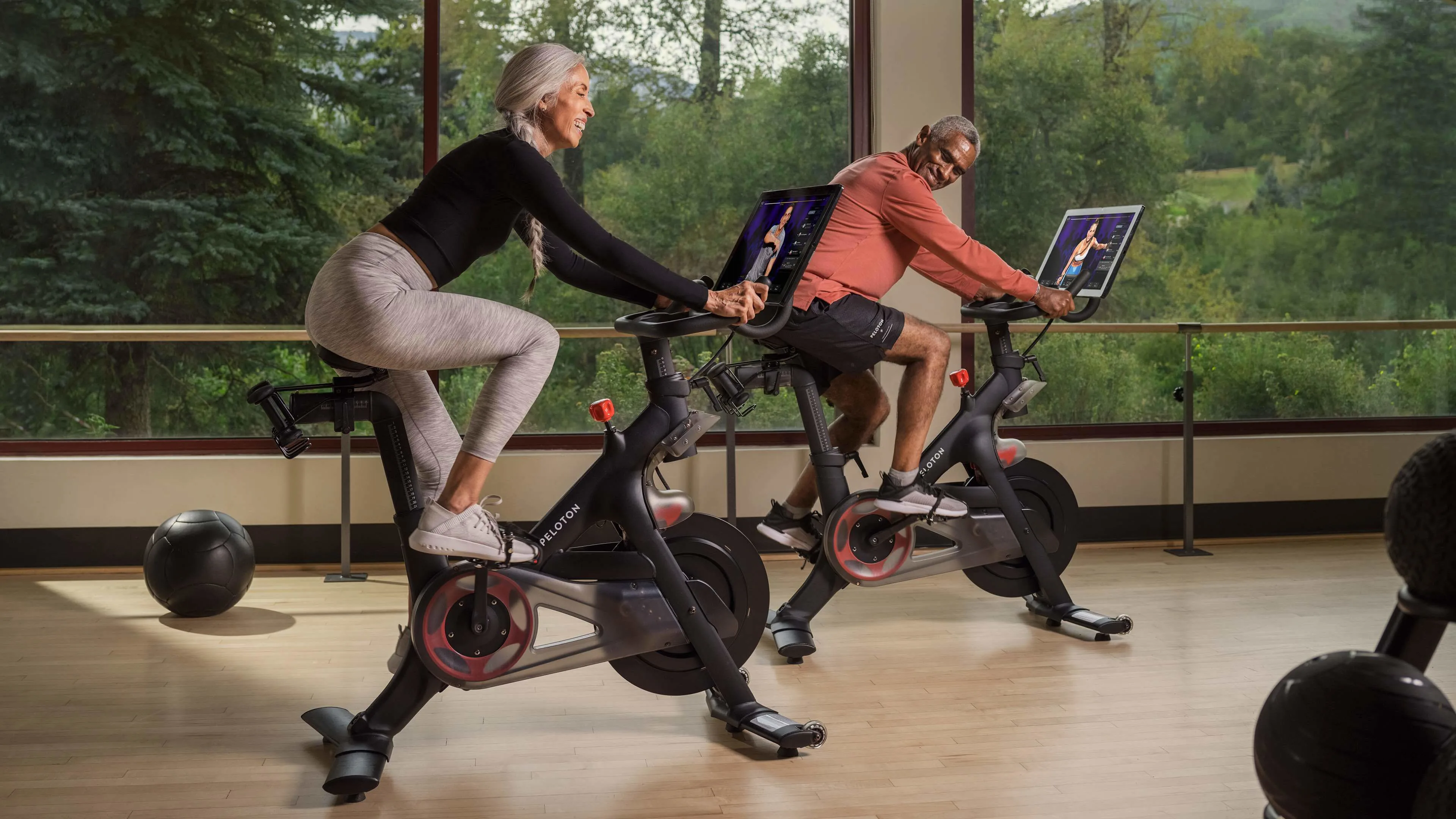 Two hotel guests using Peloton stationary bikes