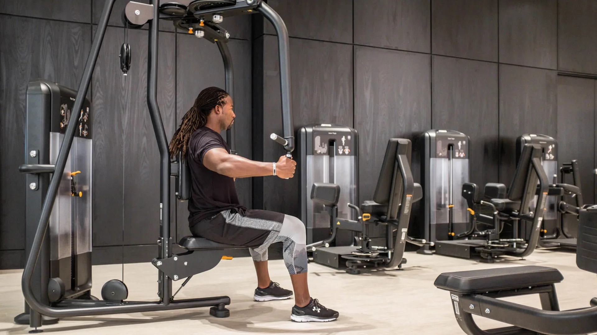 Exerciser using Precor strength equipment in a gym