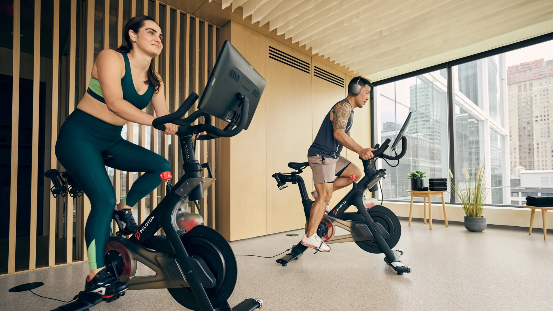Two exercisers using Peloton stationary bikes