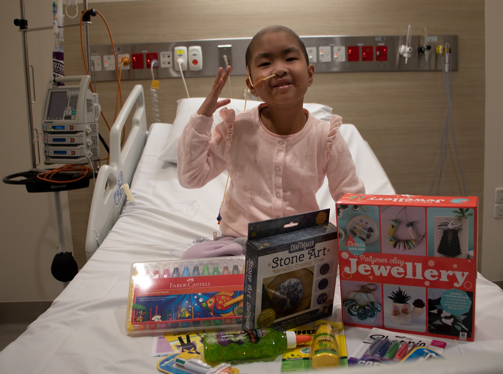 Nia on hospital bed with Christmas gifts
