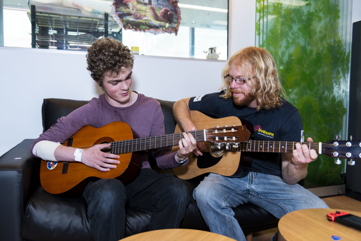 Livewire facilitator playing guitar with a teen in WA 2019