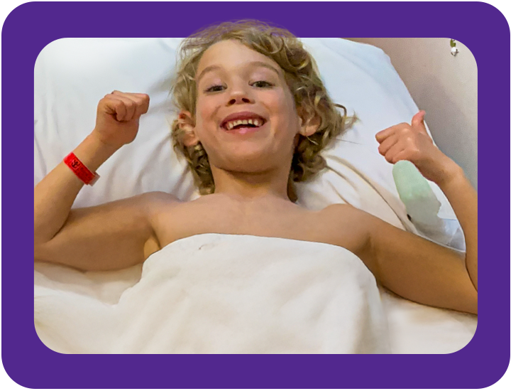 George in hospital bed smiling giving thumbs up