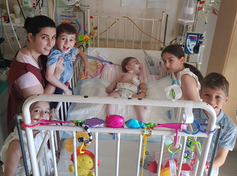 Baby Em with mum and siblings in hospital