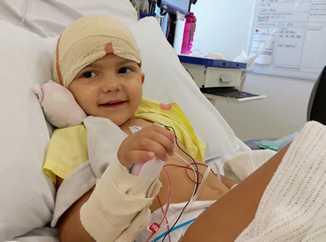 Ava with head bandaged in hospital