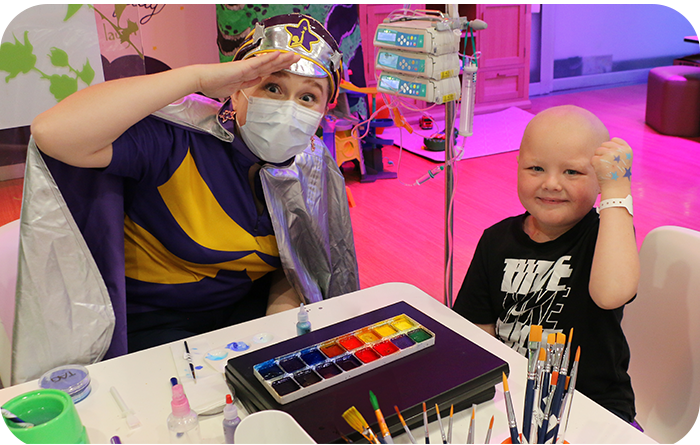 Child (Zach) and Captain Starlight in craft table in Starlight Express Room
