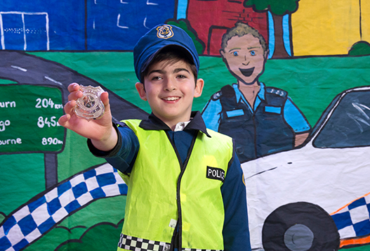 Syel in police costume holding badge