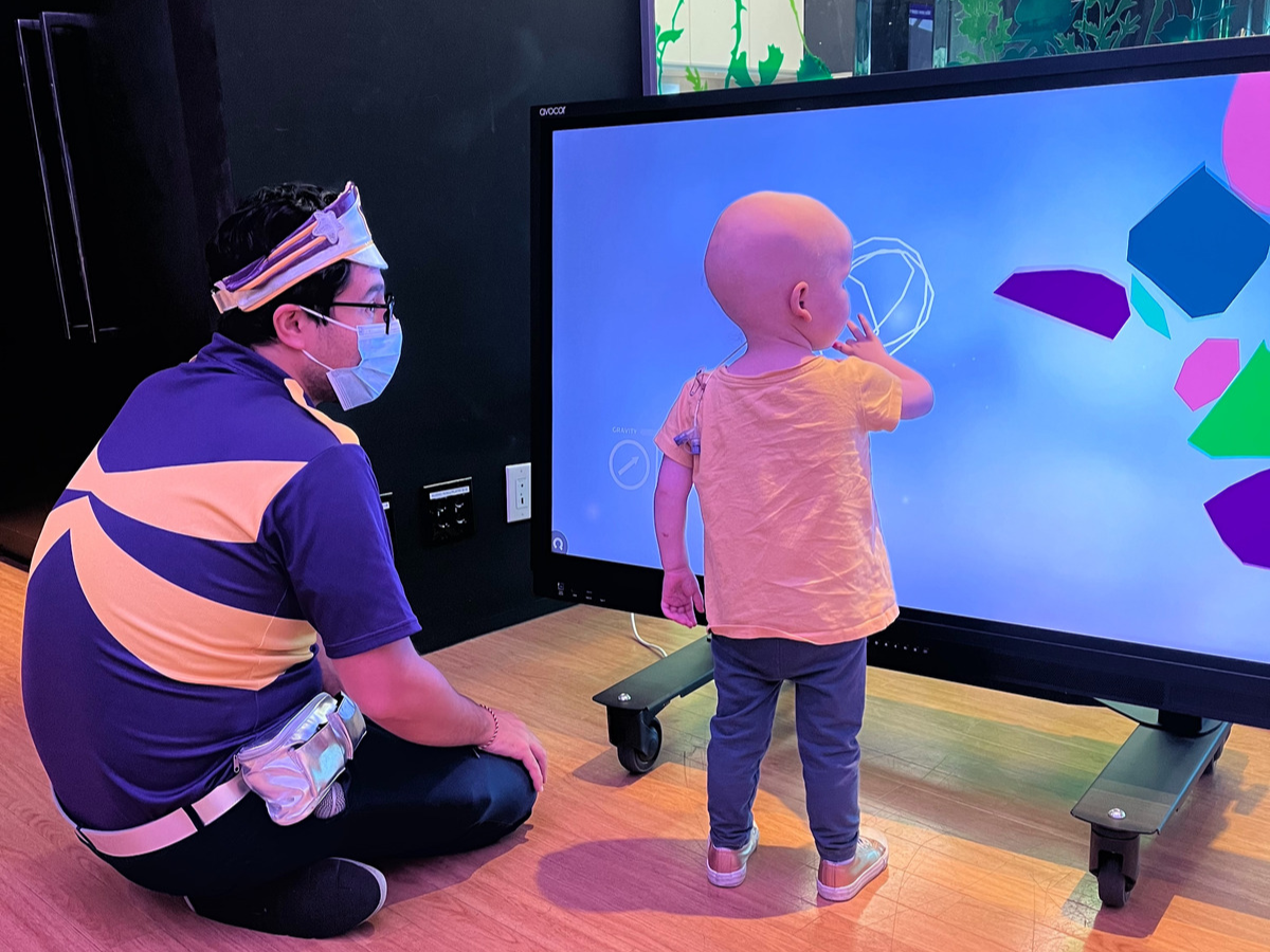 Lexi with Captain Starlight playing with interactive board