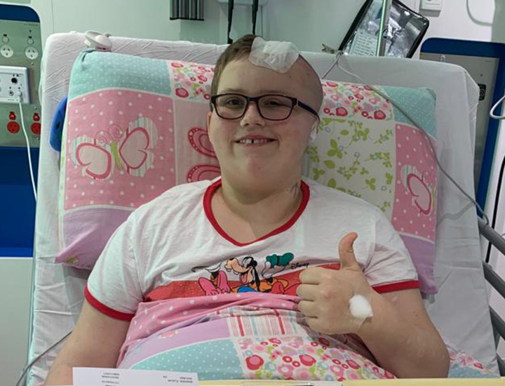 Fleur thumbs up in hospital bed - banner
