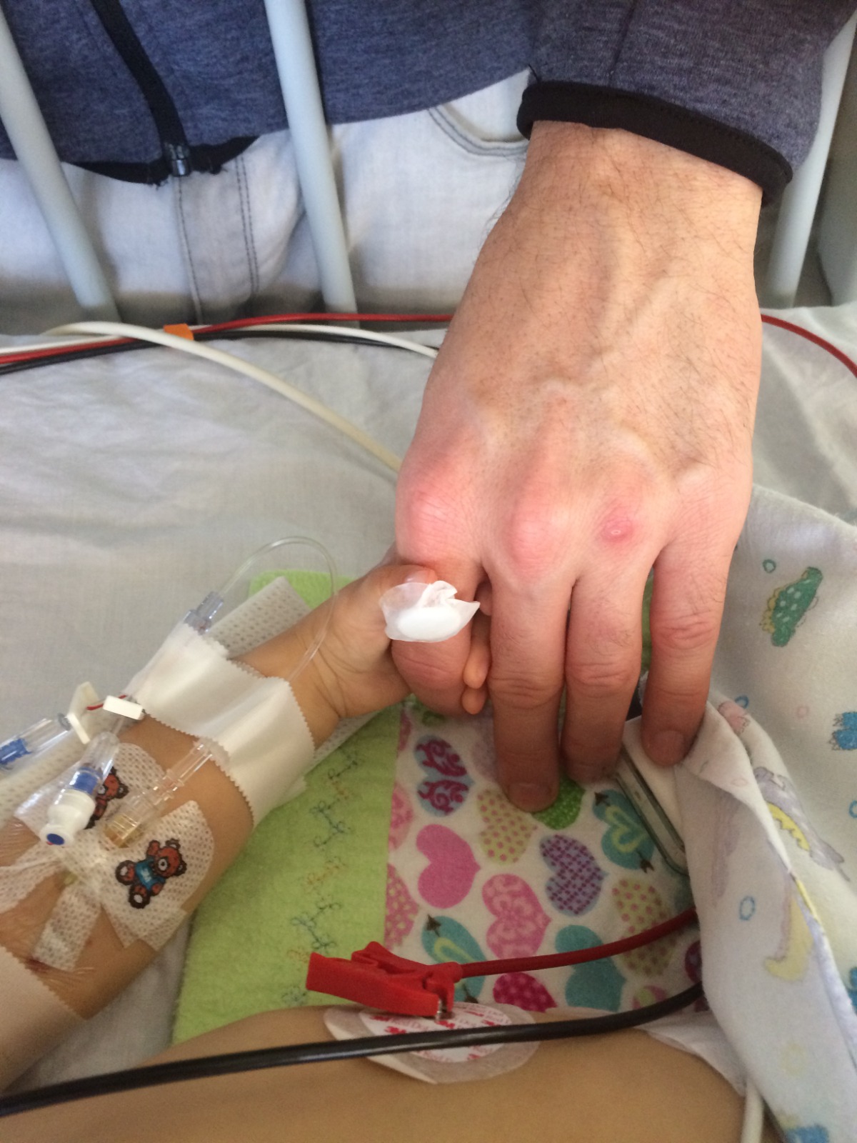 Scarlett in hospital holding Dad's hand