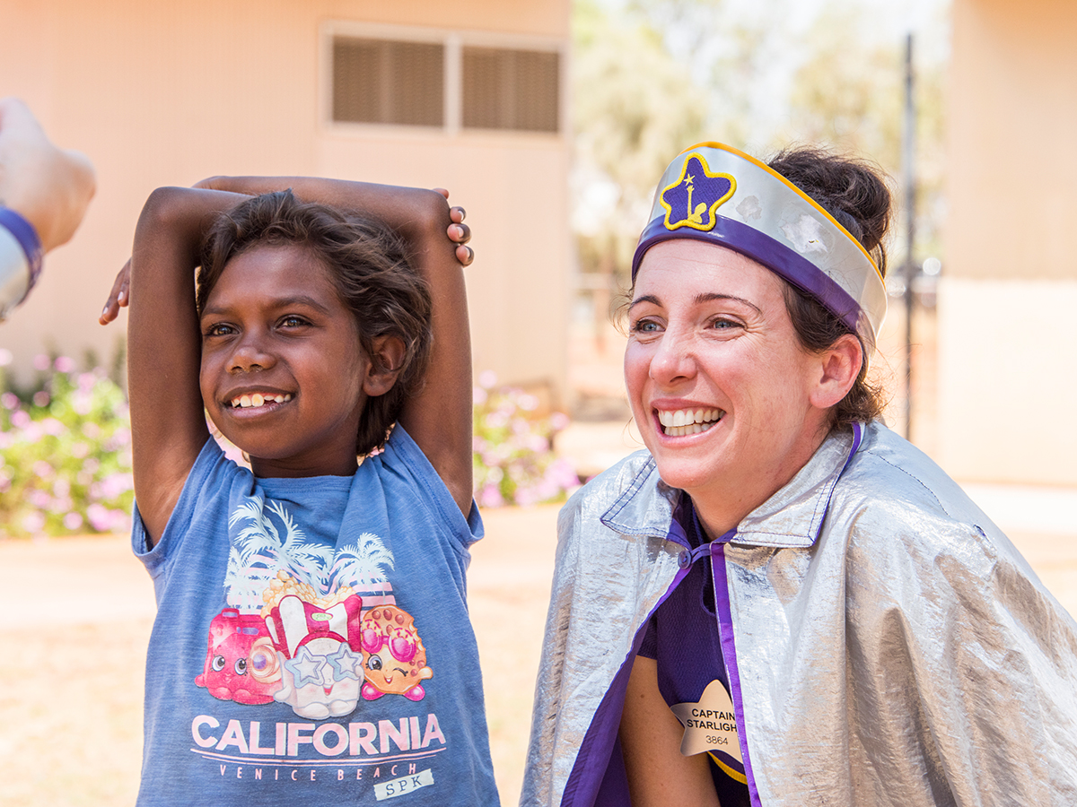 Captain Starlight and smiling girl during remote community visit