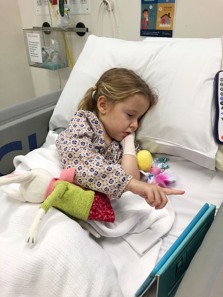 Lotte in a hospital bed with her toys