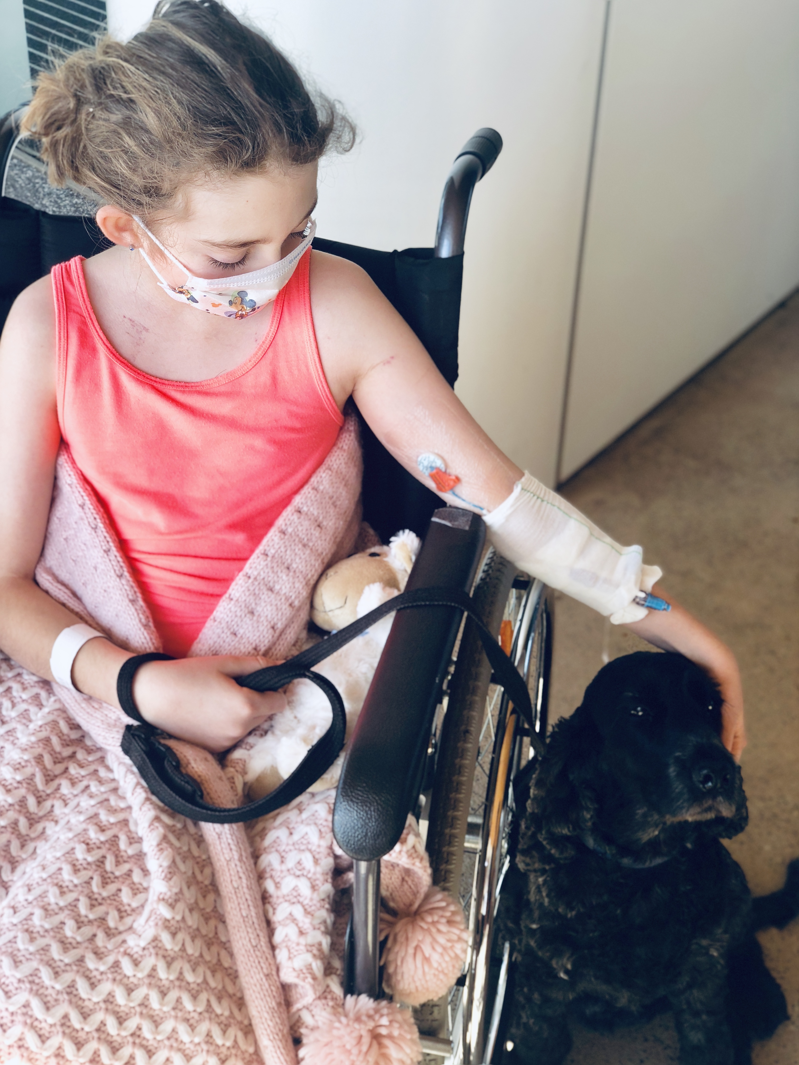 Emily in wheelchair patting service dog