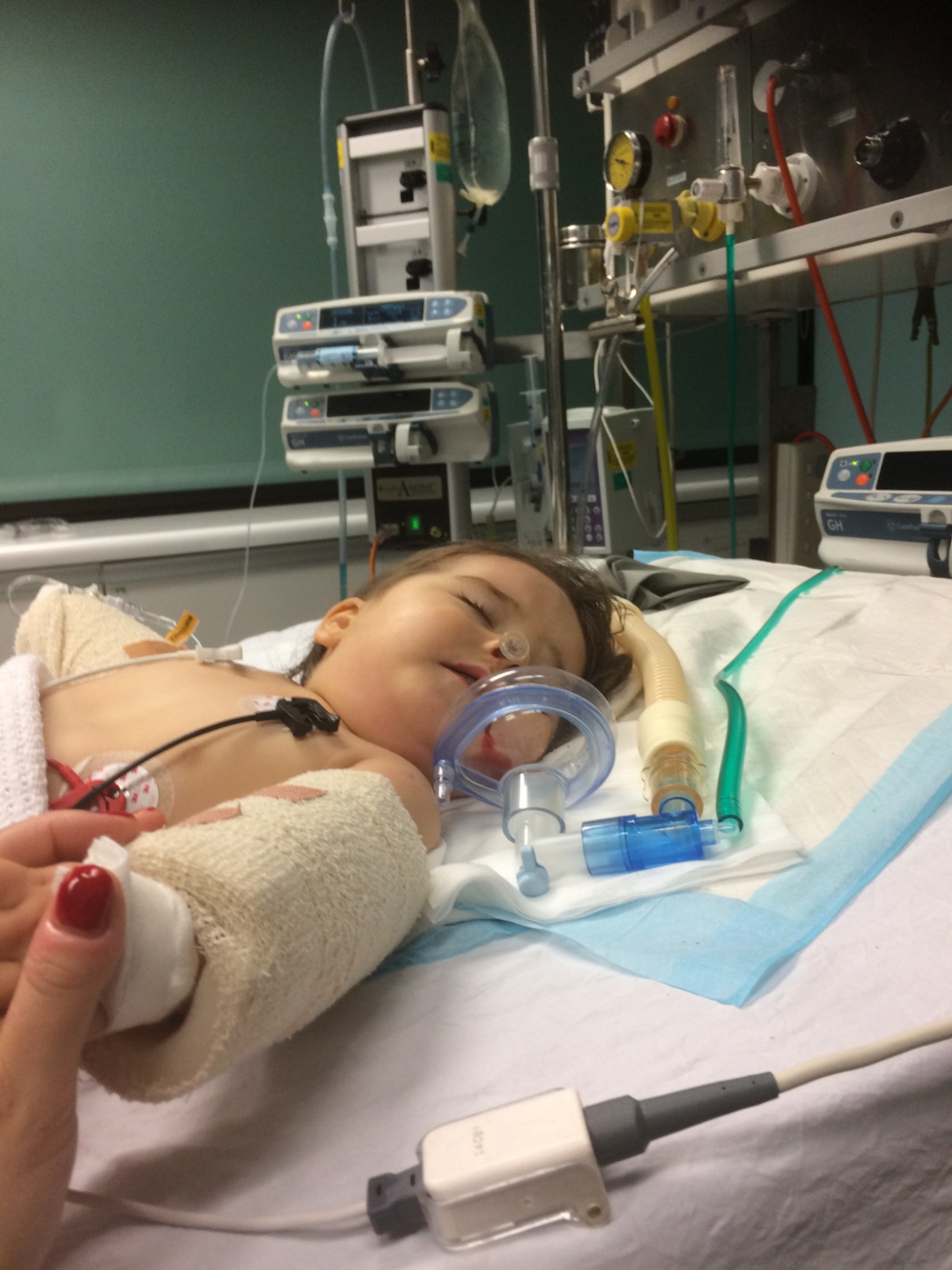Scarlett in hospital holding Mum's hand