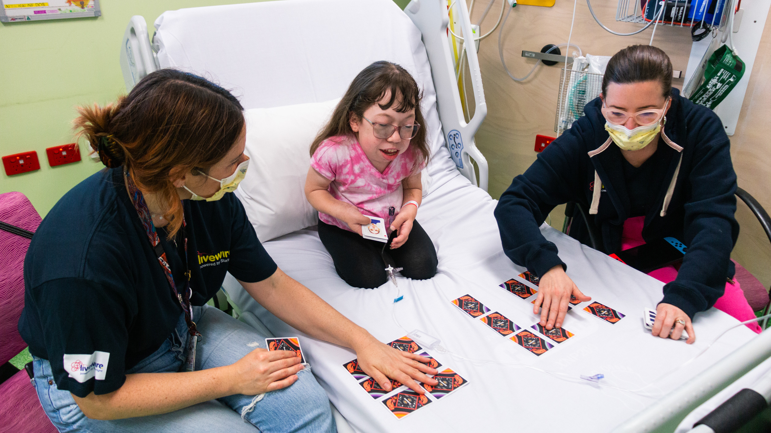 Sophie and facilitators playing card games on the ward