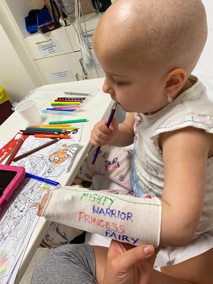 Isla playing craft in her hospital bed