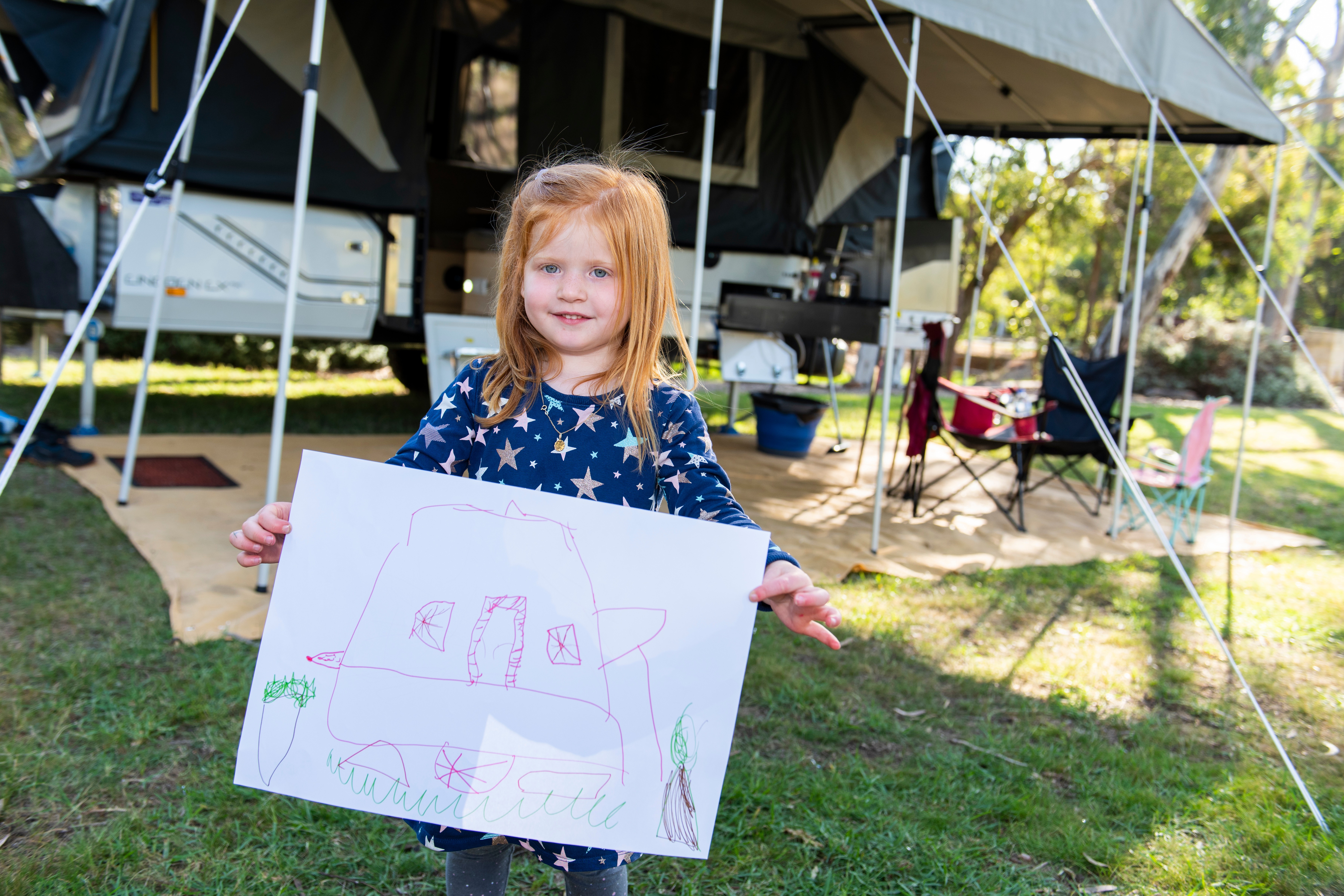 Nora holding picture she did on a family camping trip