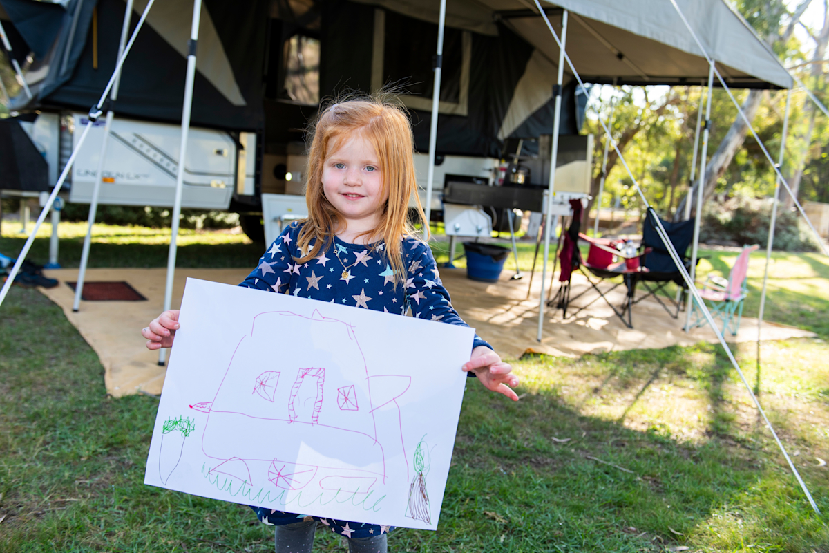 Nora holding picture she did on a family camping trip