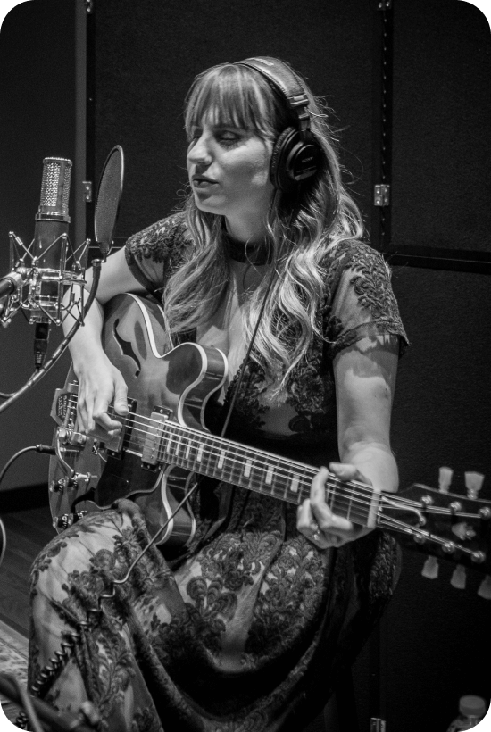 Woman playing guitar in the studio