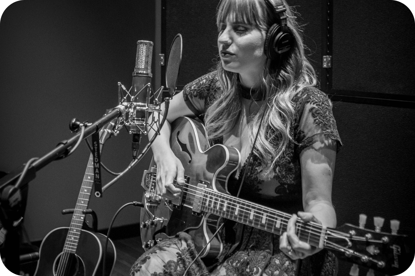 Woman playing guitar in the studio