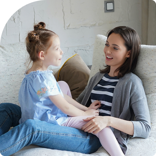 An image of a woman with her daughter on her lap, talking about something and smiling