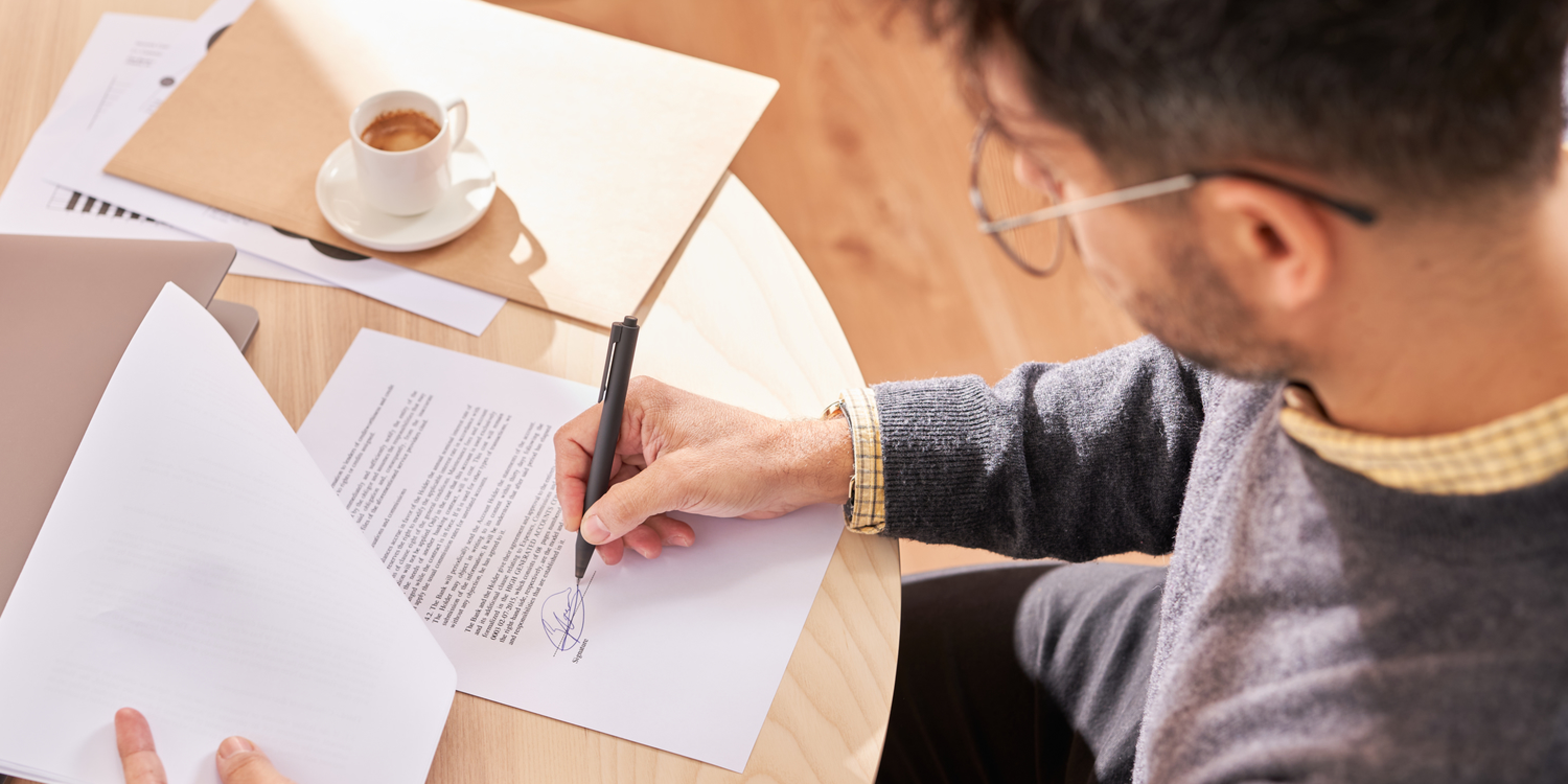 A hero image of a renter signing a lease and he may need a guarantor 