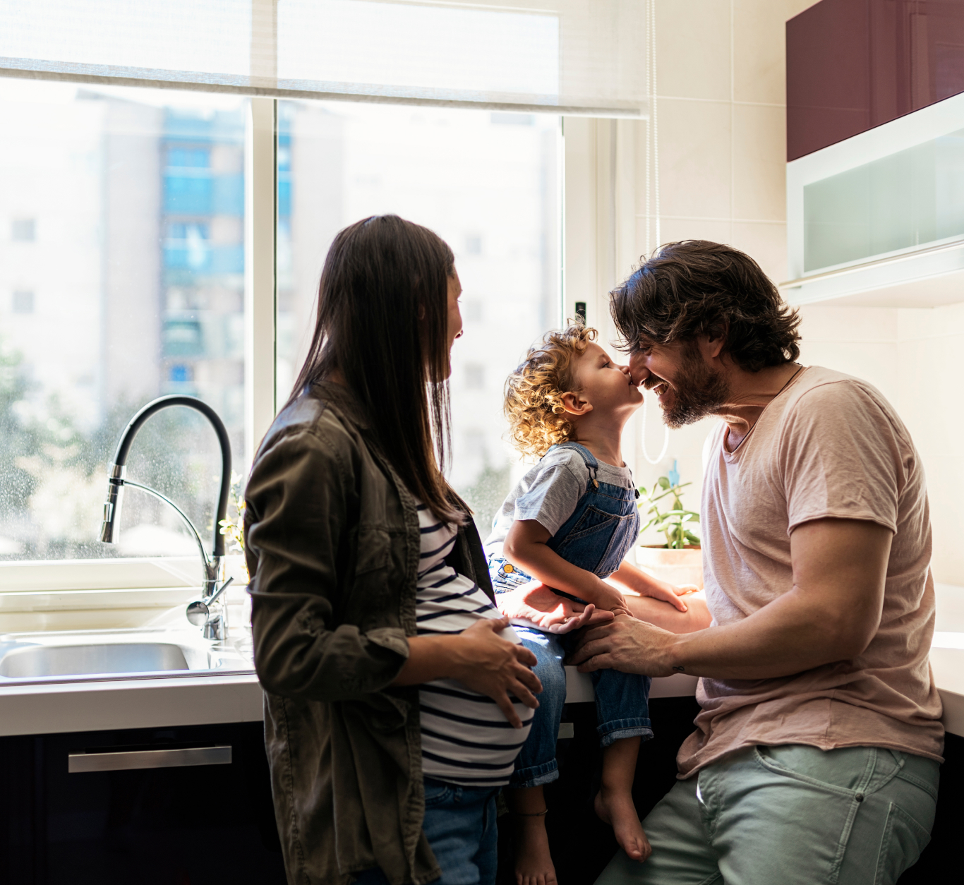 Family standing in a kitchen in front of a window