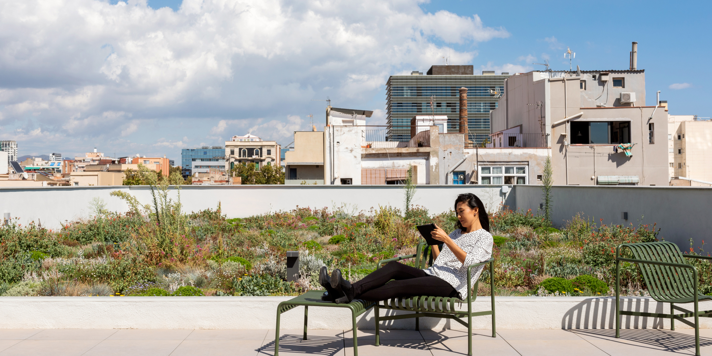 An image of a millennial person on a rooftop using her tablet 