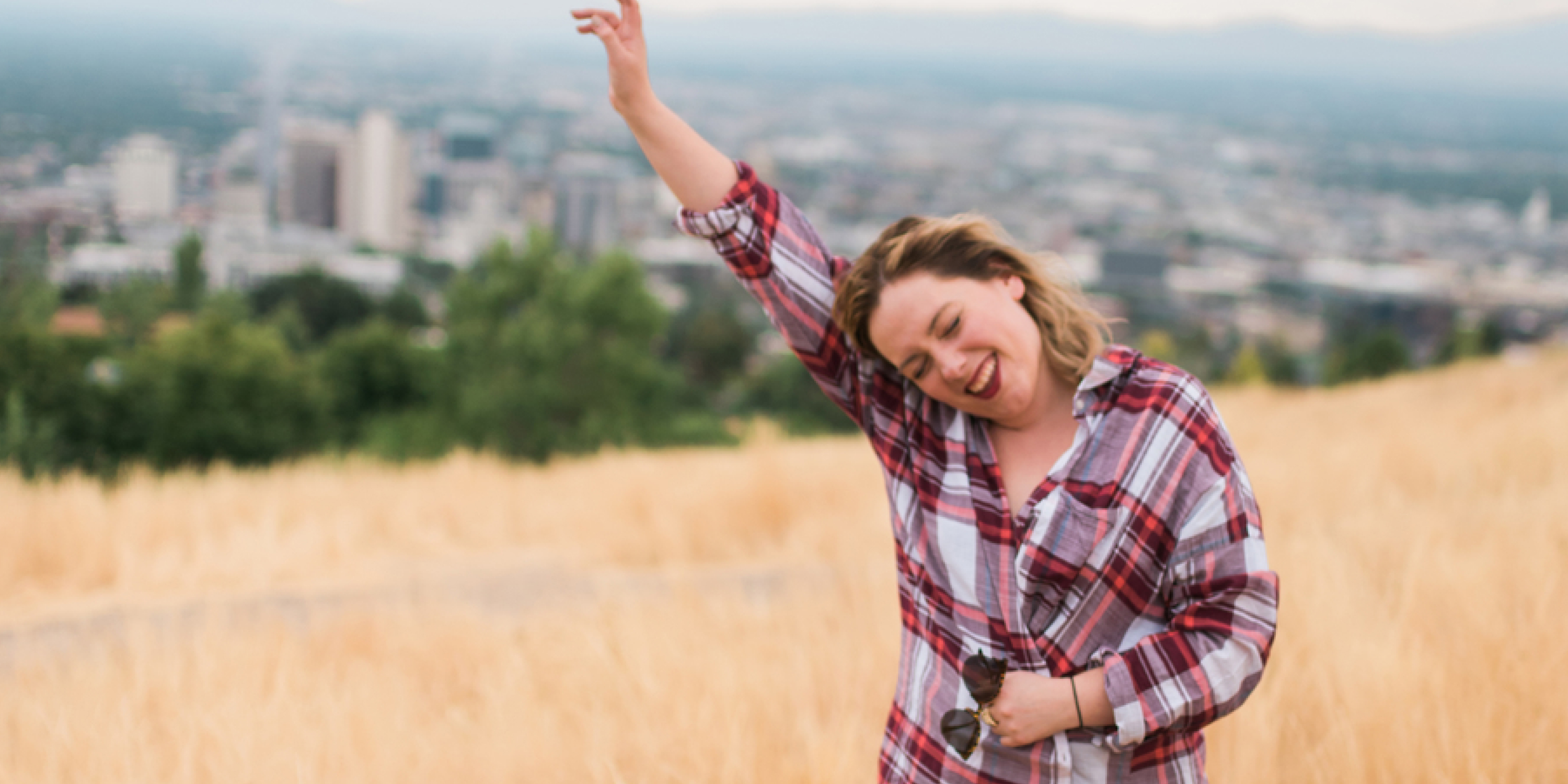 An image of a person on a Capitol Hill overlooking Salt Lake City. She is happy that she has moved to Salt Lake City. 