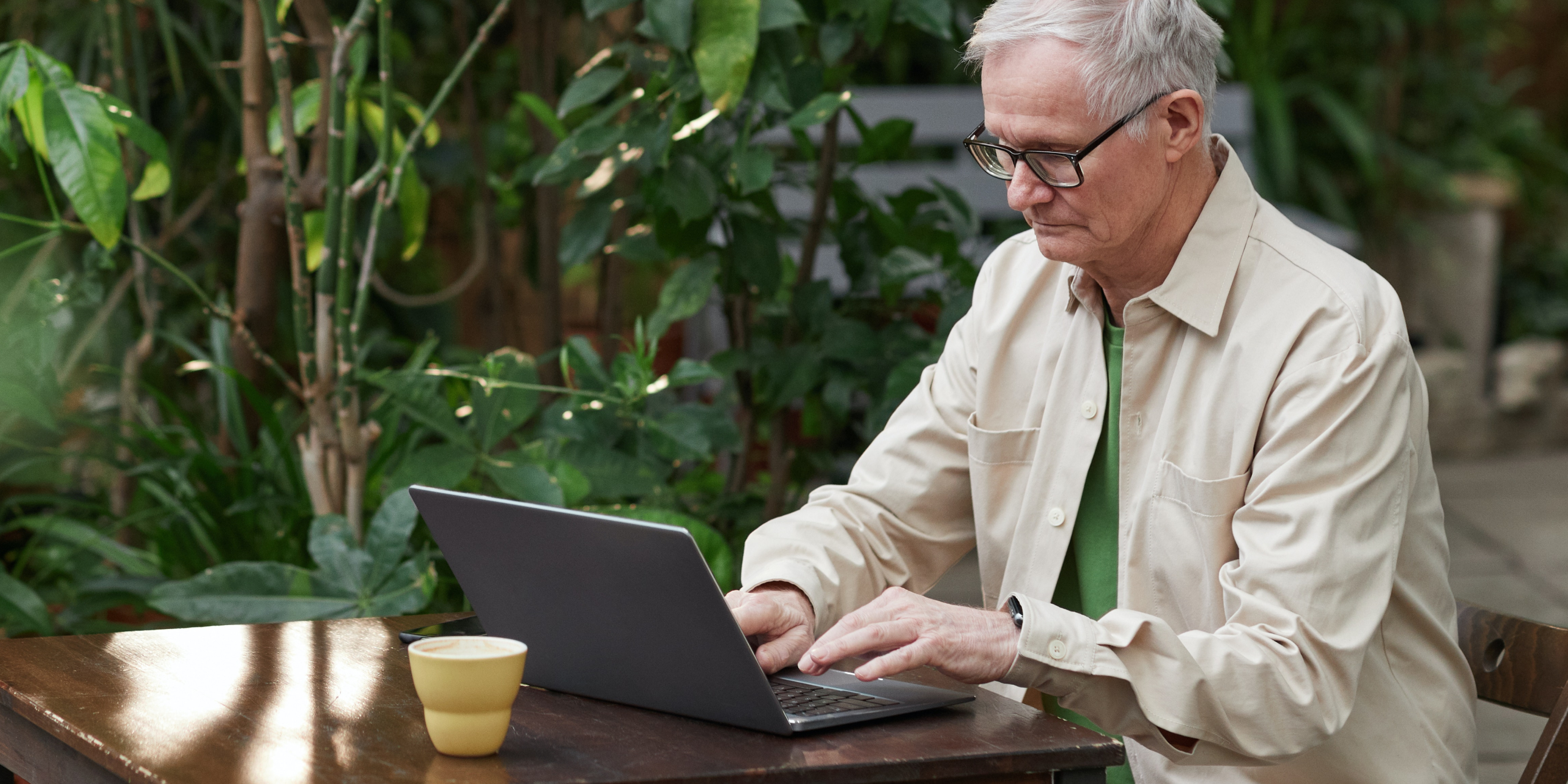 An image of a property owner filing a claim with Rhino on his laptop in a green garden