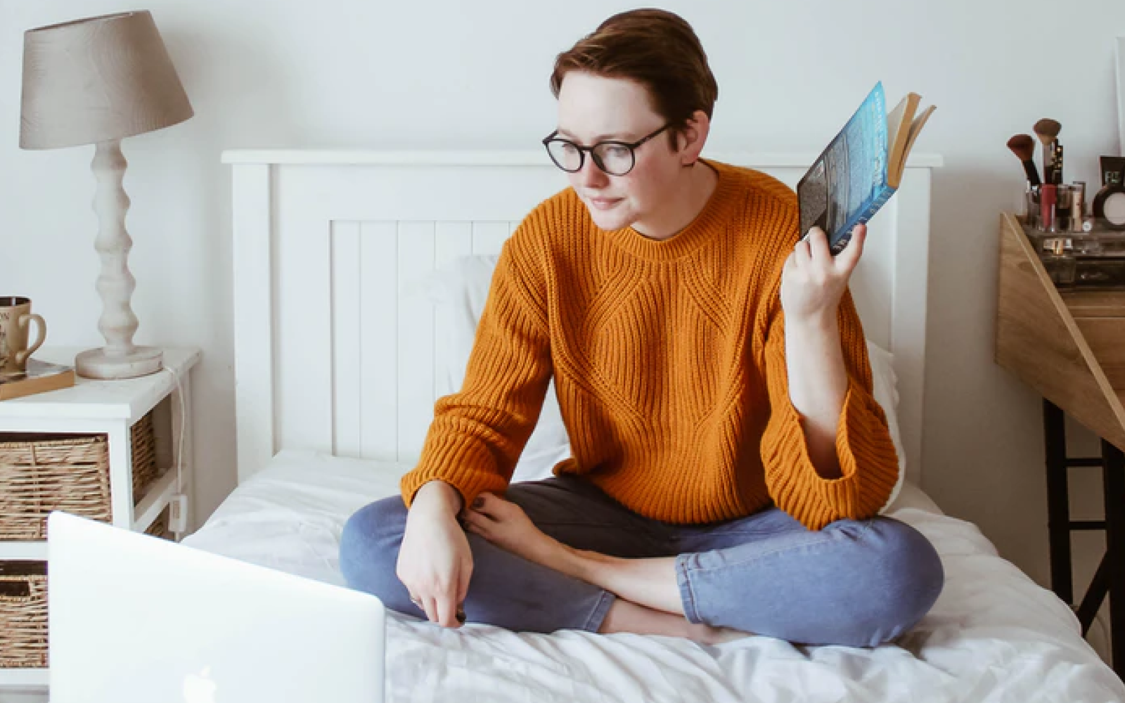 Image of a student studying on their bed in their rented apartment