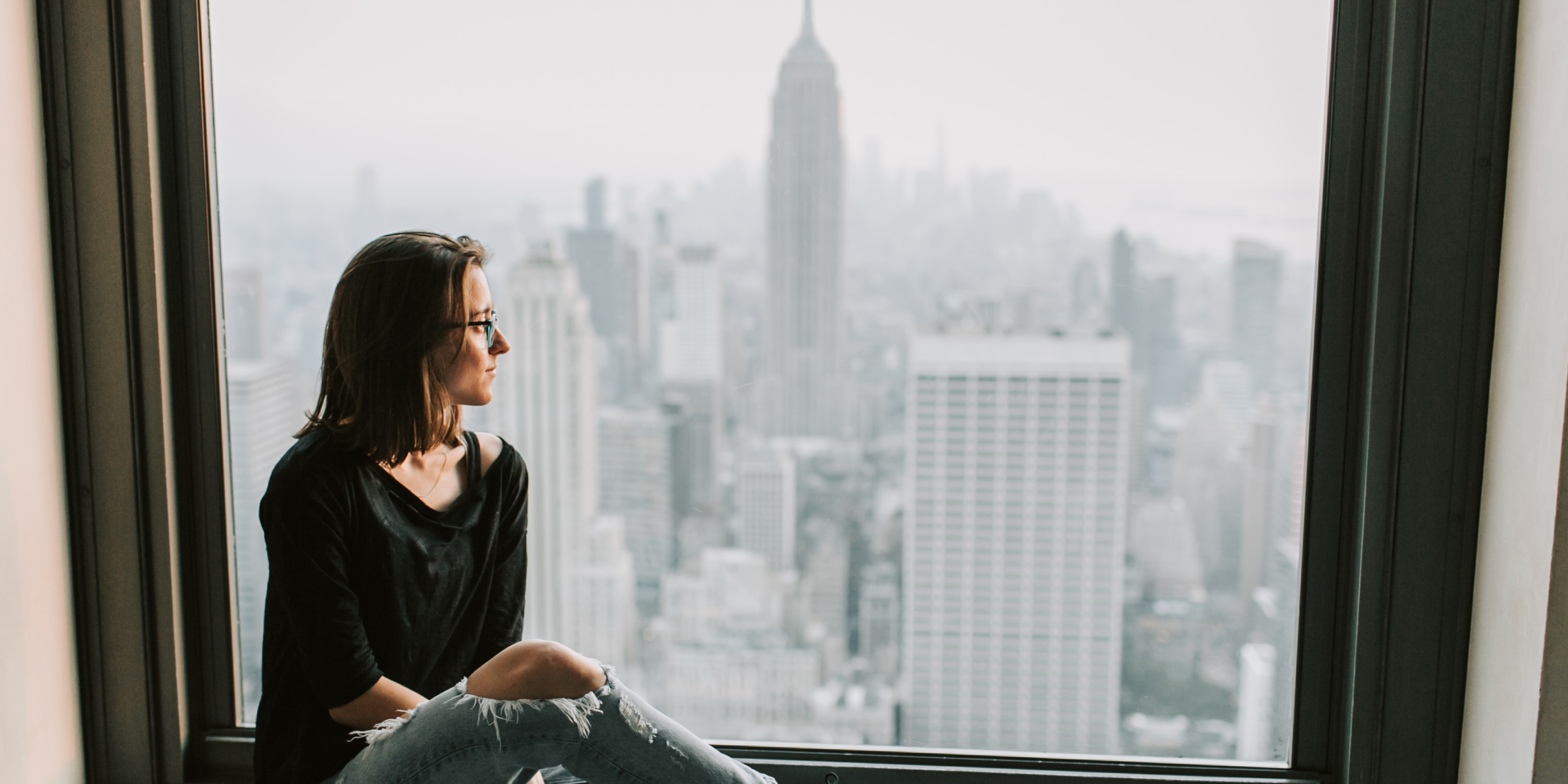 An image of a renter looking out their window at the Empire State Building 