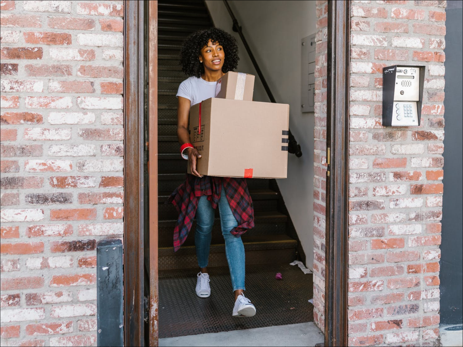 Image of a renter carrying boxes outside, while moving