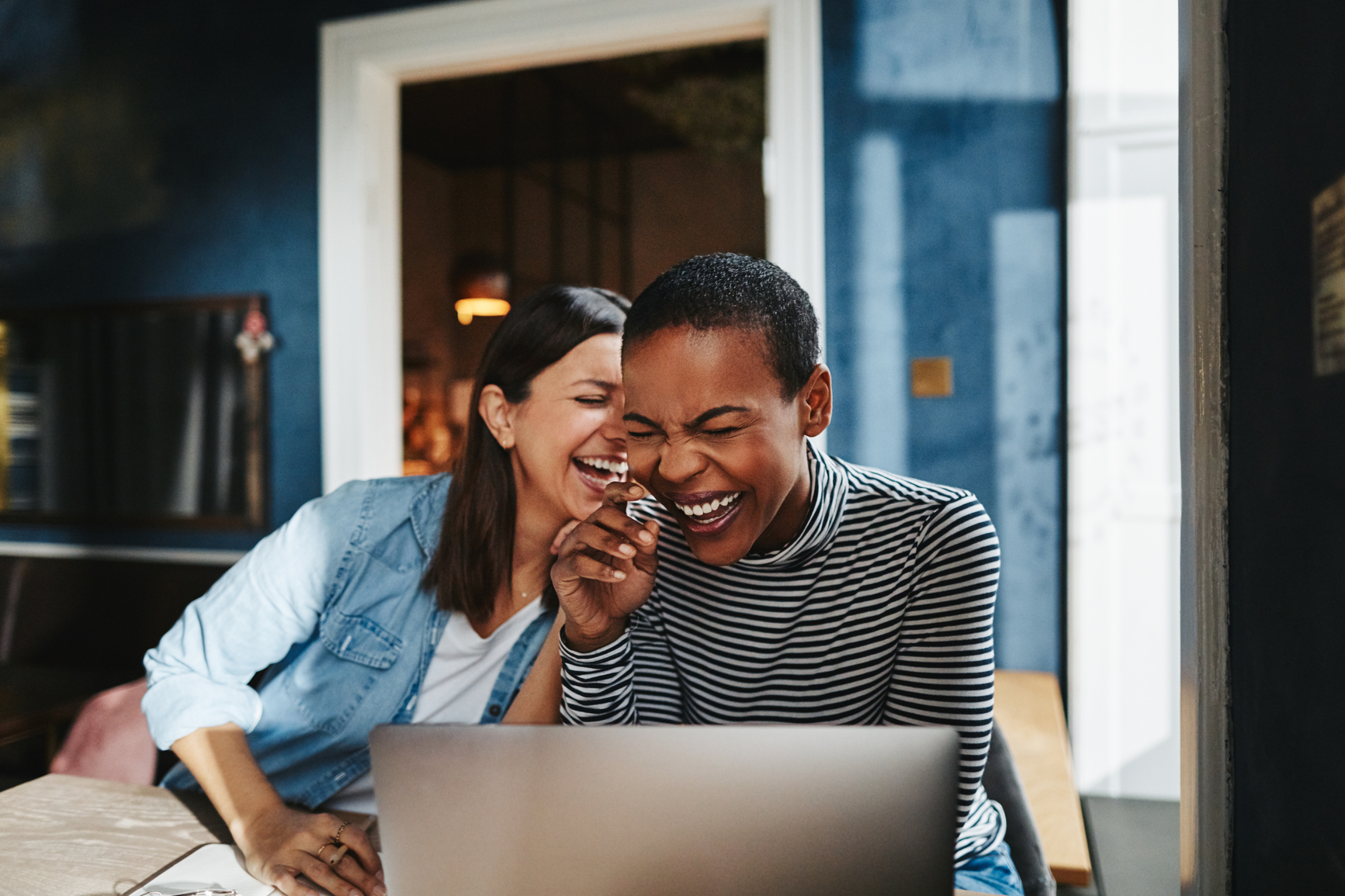 An image of two renters using a laptop at a kitchen table 