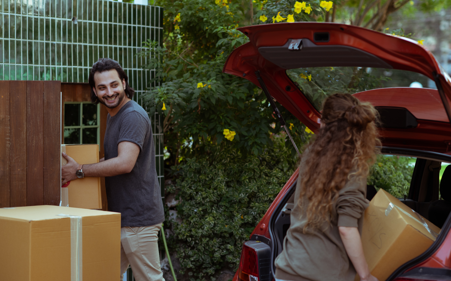 Image of two renters packing a car with boxes 