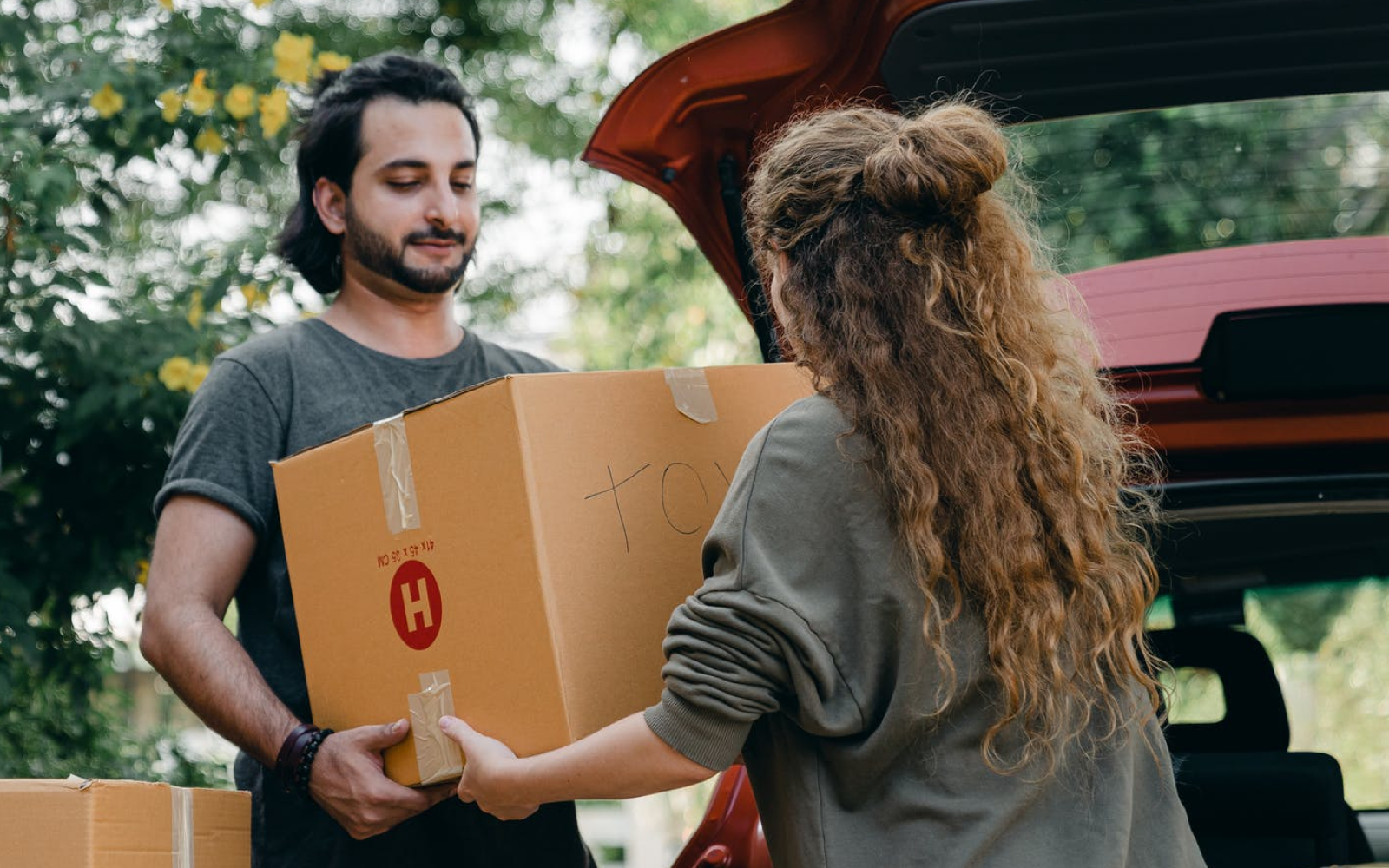 Image of renters with boxing boxes outside their car.