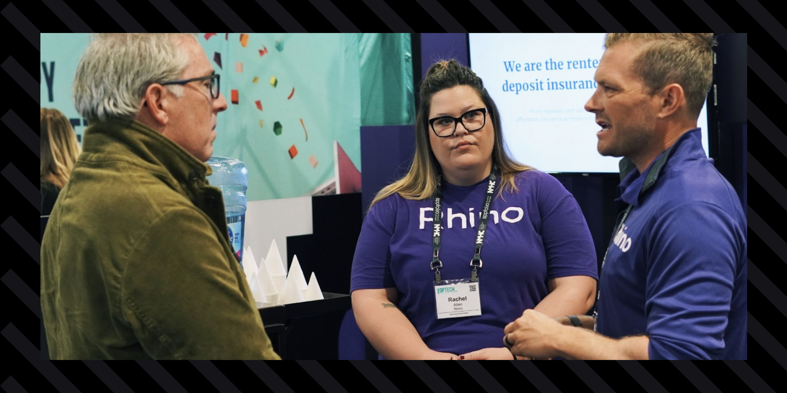 An image of two Rhino employees, Rachel Allen, and Eric Krauss talking to a booth visitor at OpTech 2021 