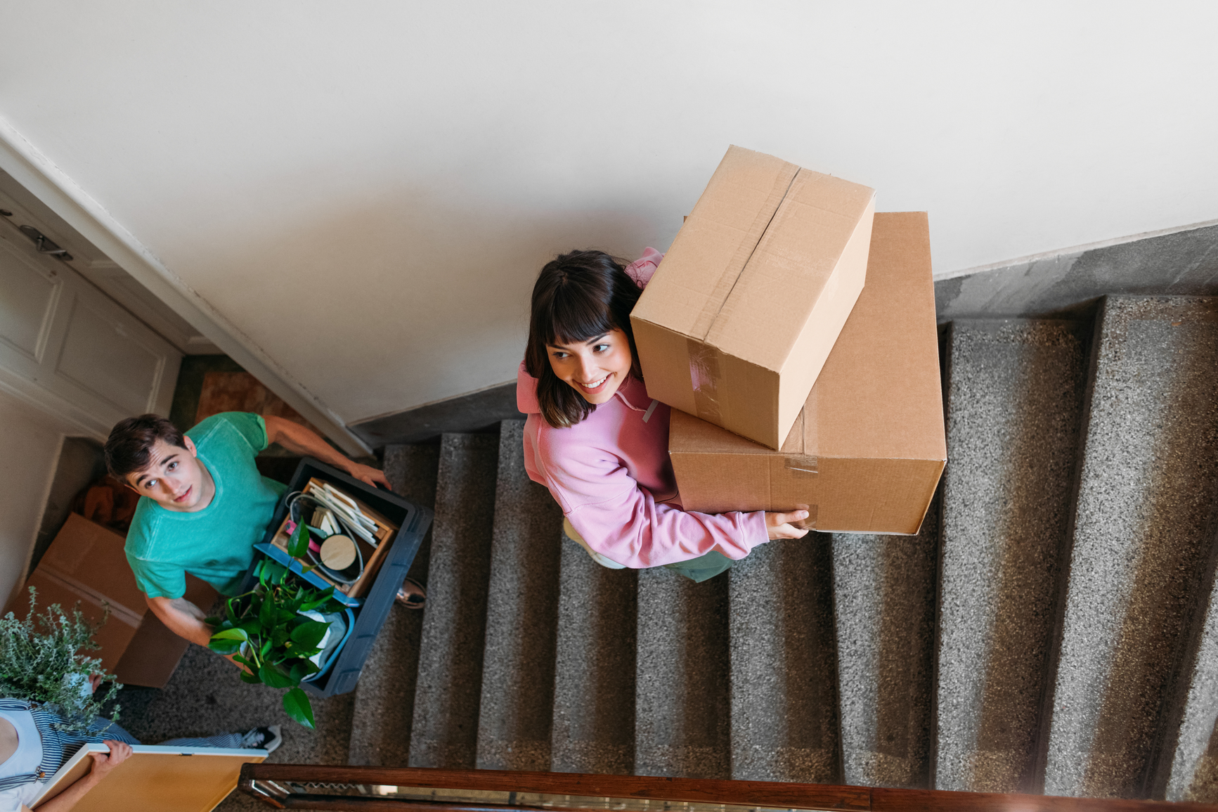 A photo of two renters carrying large boxes up the stairs. 