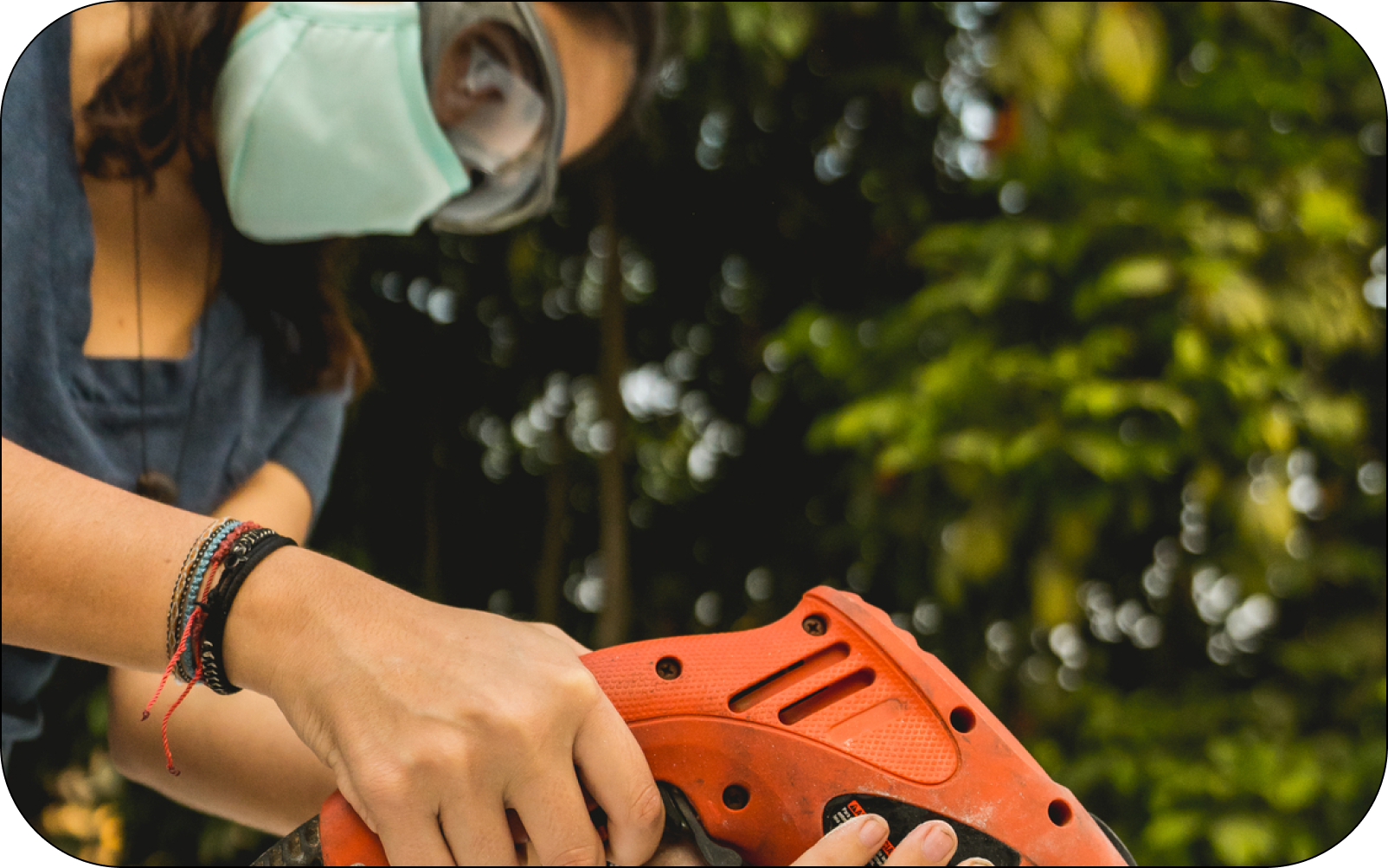 Image of a property manager completing outdoor repairs with a drill and a face mask on 