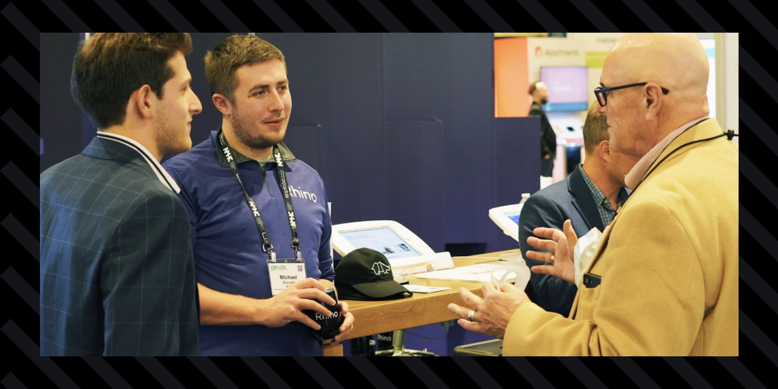 An image of Rhino employees David Berardi and Michael Brevdah talking with a visitor to the Rhino booth at Optech 2021 
