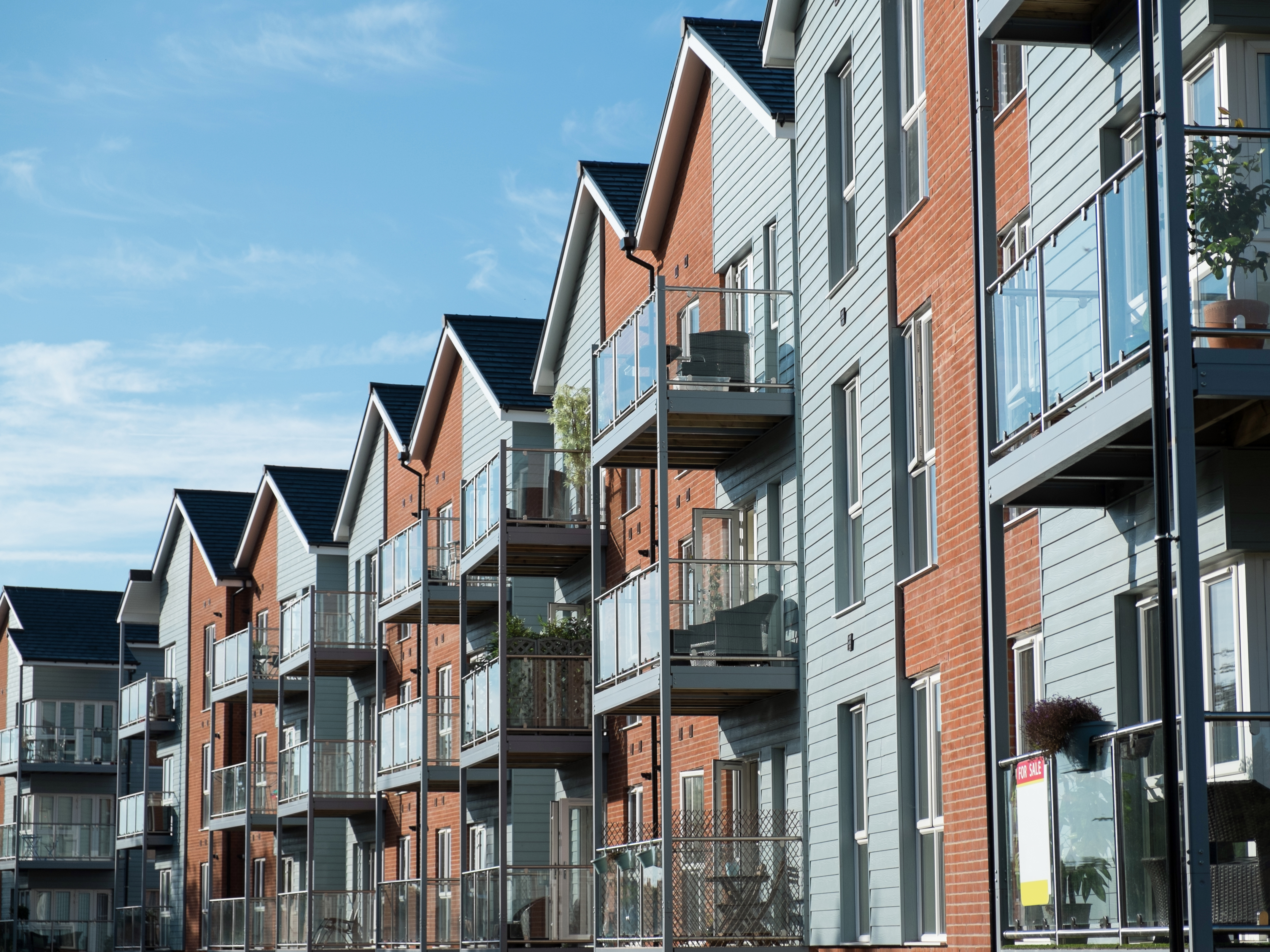 Blue sky and brick and siding multifamily apartment building