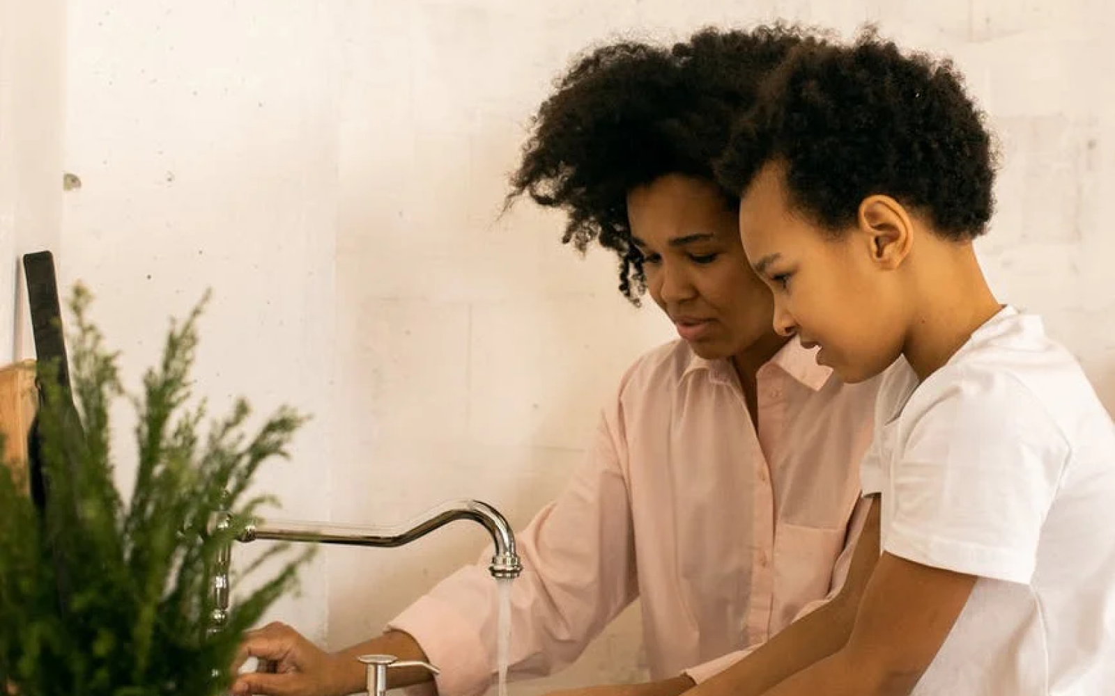Image of a renter and child using the sink in their kitchen 