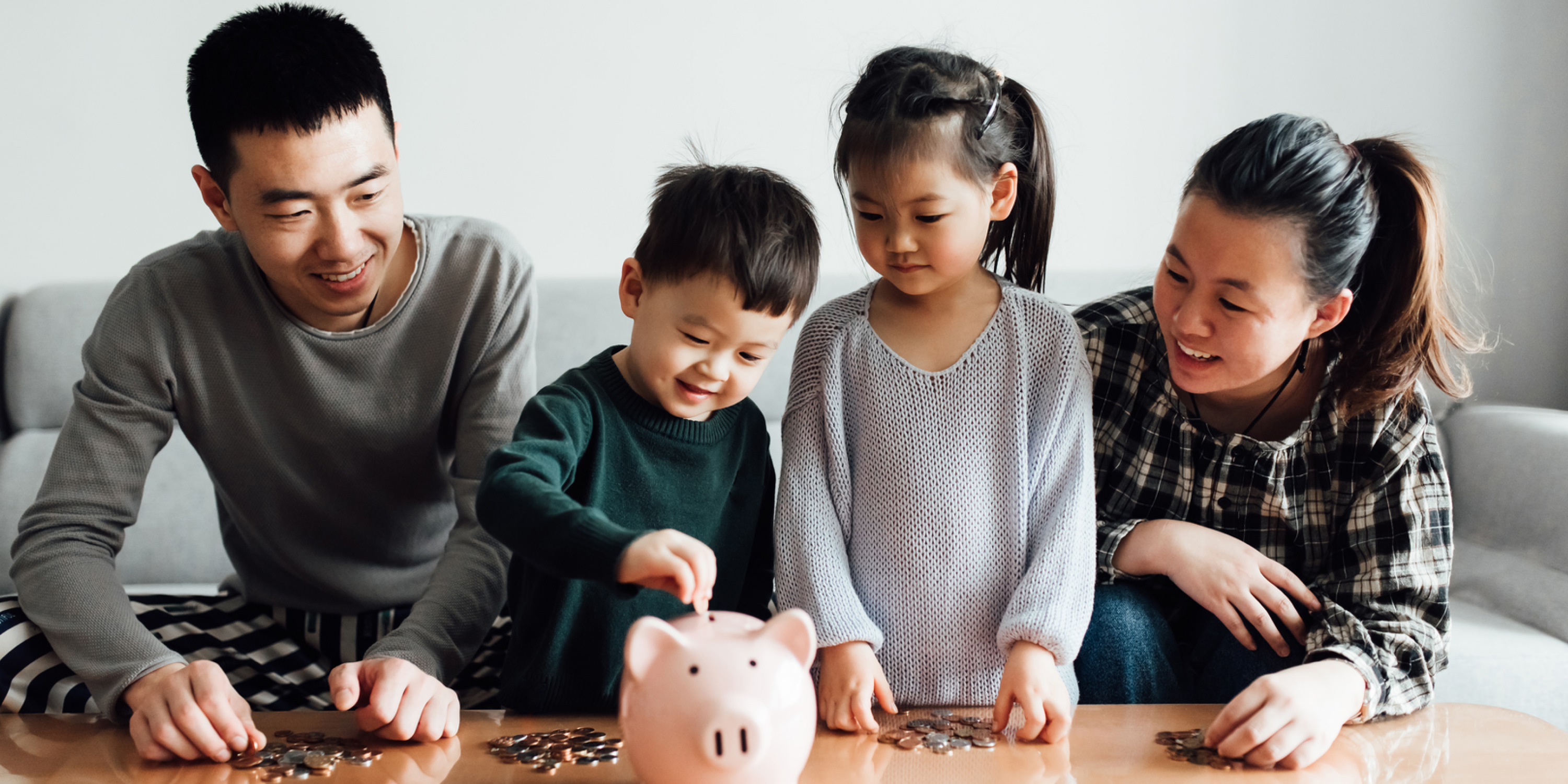 An image of a family putting their coins in a piggy bank 