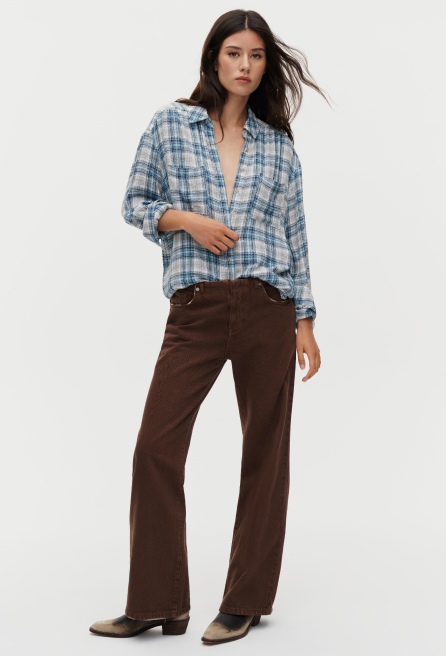 Woman wearing blue and white plaid button-up shirt with brown wide-leg corduroy pants and brown leather boots