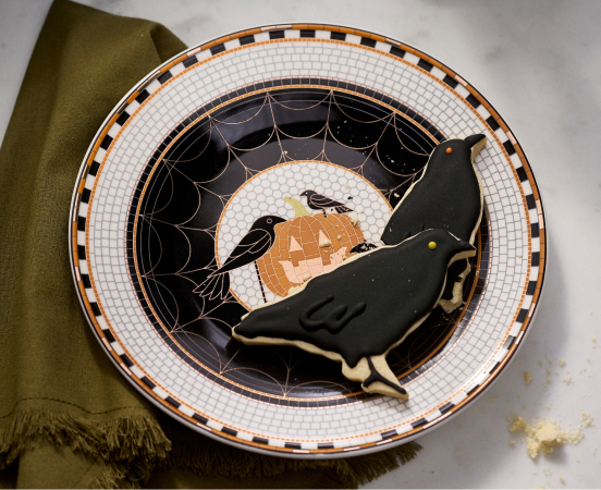 Halloween plate with black cat silhouette, ravens, orange pumpkin, and spider web design on white checkered background with orange and black border.