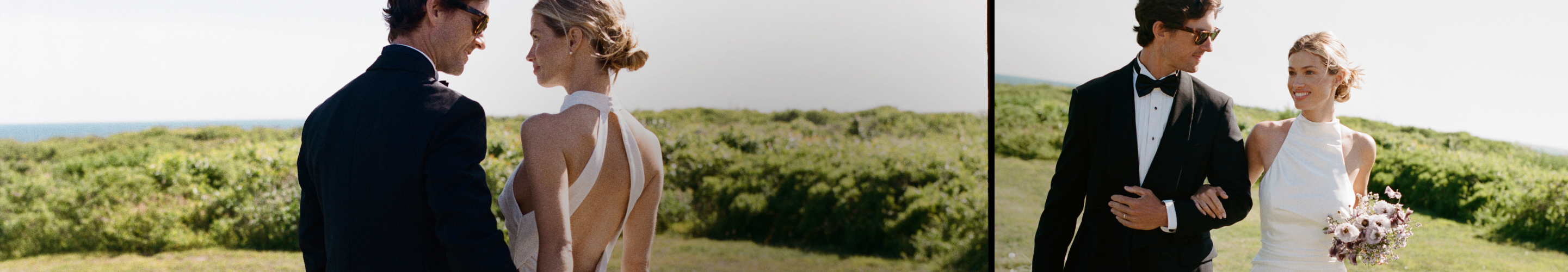 Bride and groom in formal wedding attire standing together outdoors with green landscape and ocean view in background