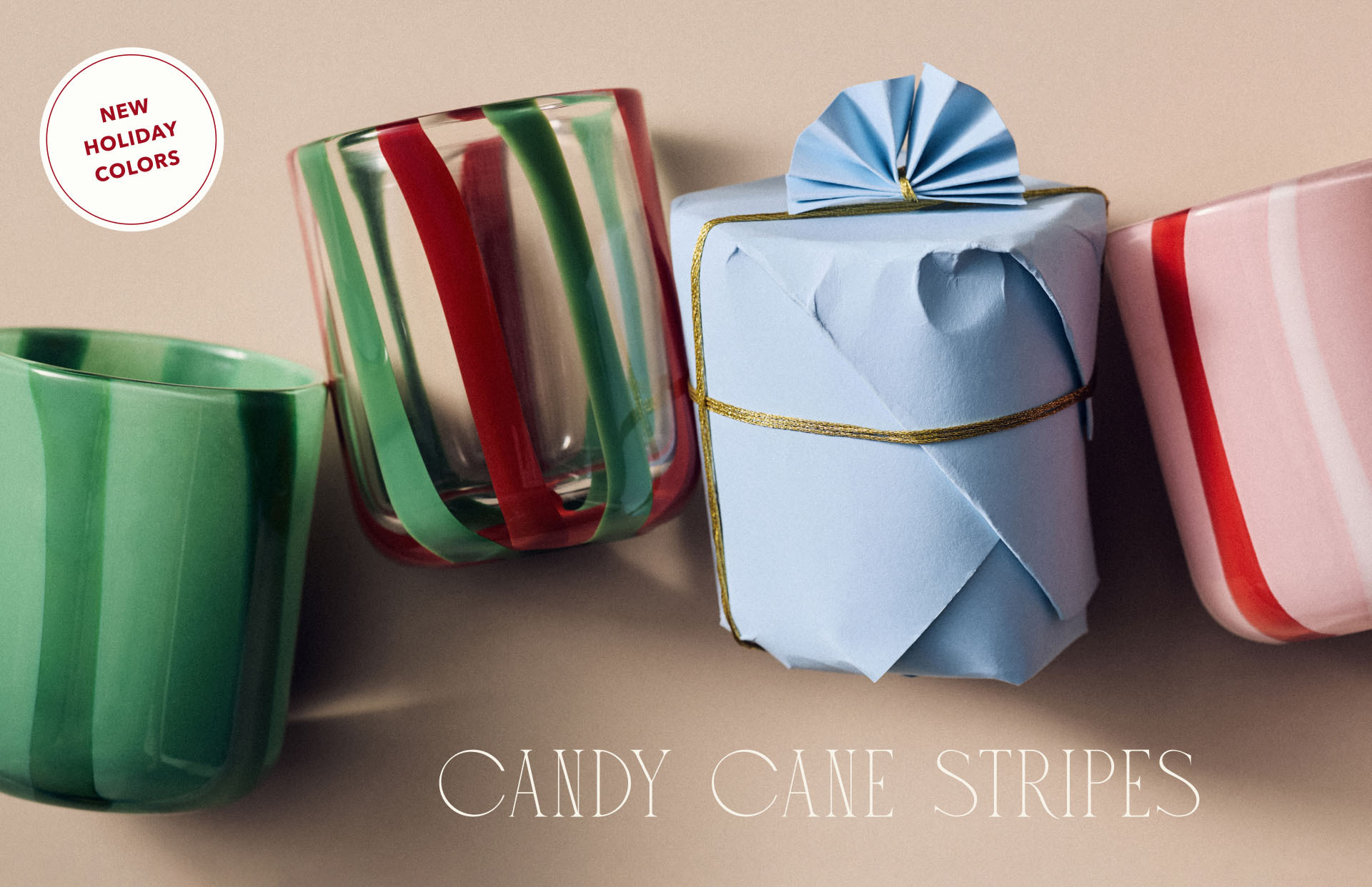 Wrapped gifts and green cup with red and green striped mug on beige background. Text reads "CANDY CANE STRIPES"